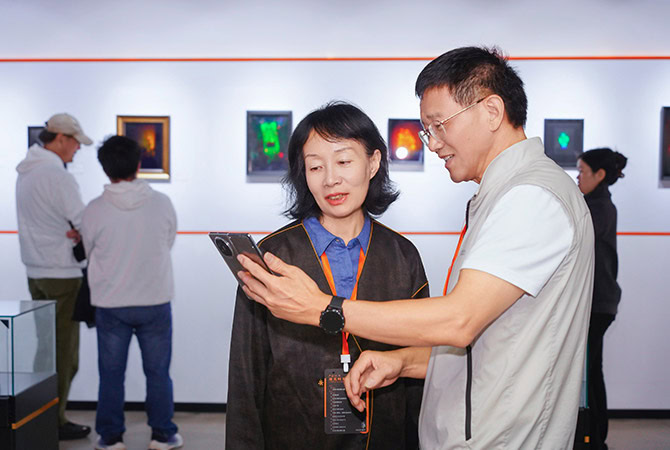 Visitors viewing and discussing holographic artworks at the Holography Technology Art Works Exhibition